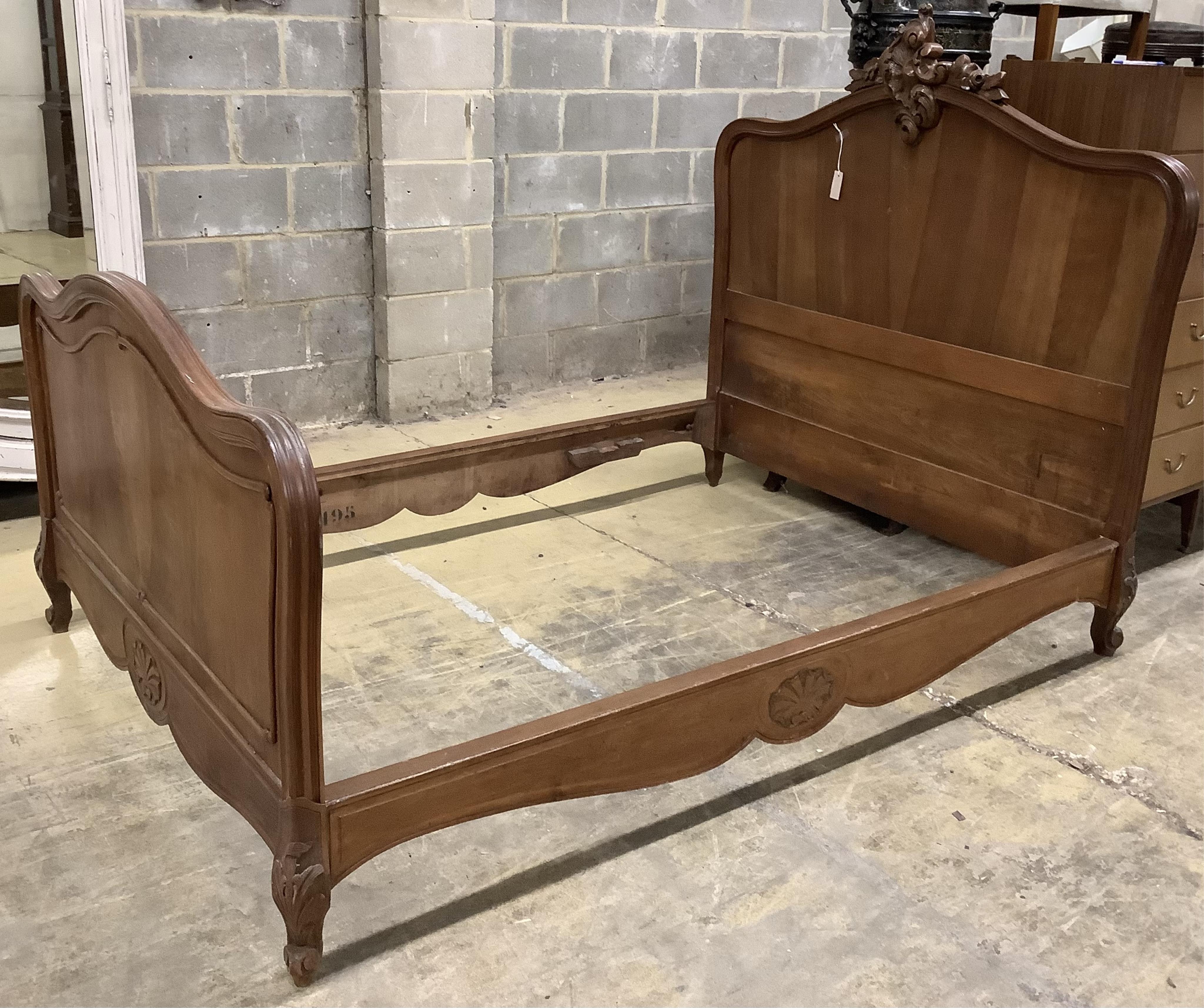 An early 20th century French walnut bedframe, width 140cm, length 199cm, height 142cm. Condition - fair